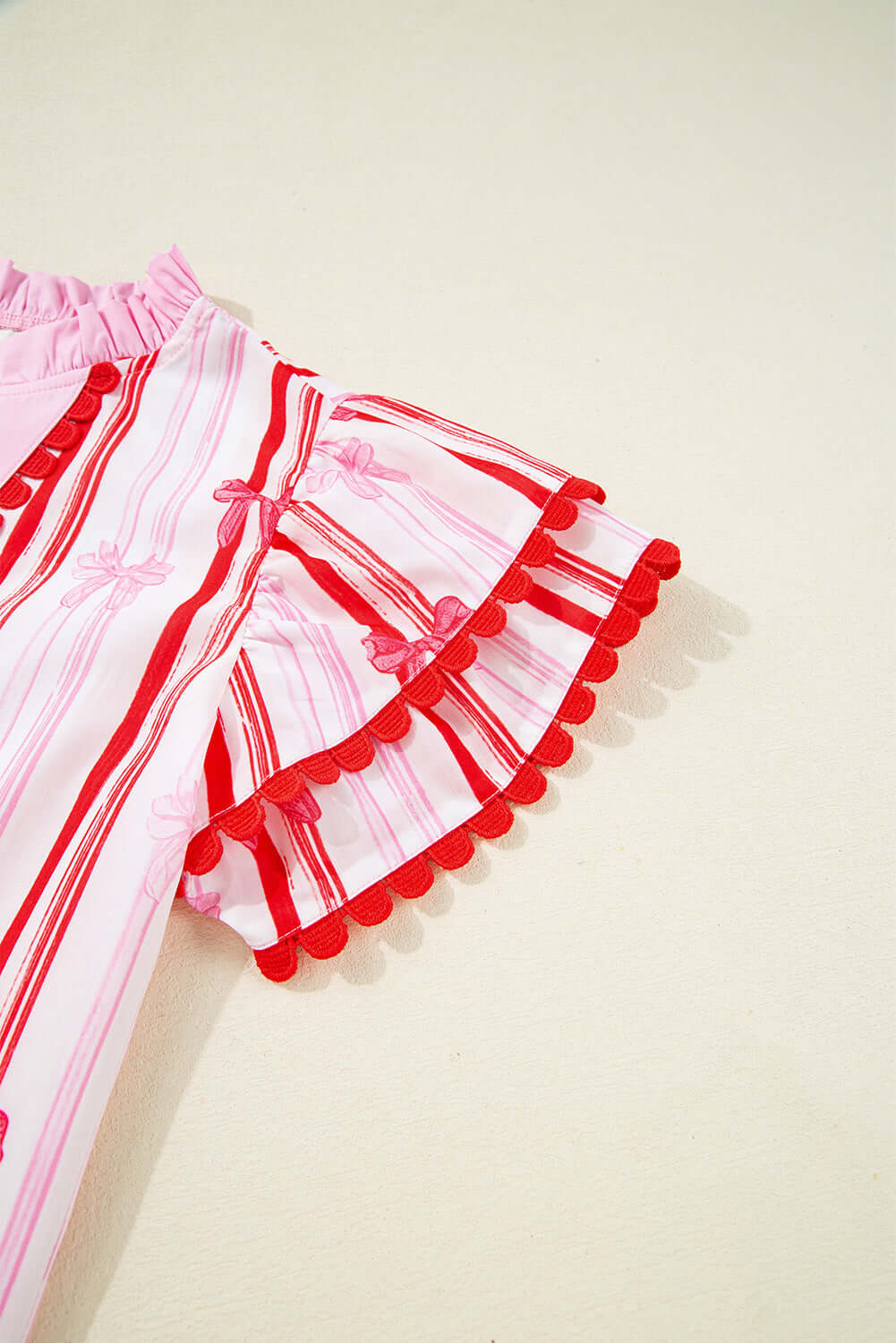 Flirty Ribbon Reign Top featuring bow print and bold ric-rac trim, perfect for warm-weather fashion.