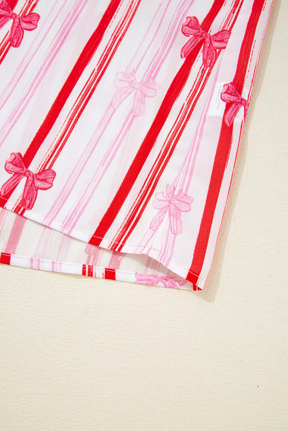 Colorful striped fabric of the Ribbon Reign Top featuring playful bow print and ric-rac trim.