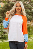 CITRUS CRUSH TOP model wearing color block pullover with tangerine sleeves and blue cuffs, perfect for casual outings.
