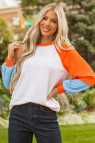 CITRUS CRUSH TOP featuring bold tangerine sleeves, soft sky blue cuffs, and a light grey body for playful style.