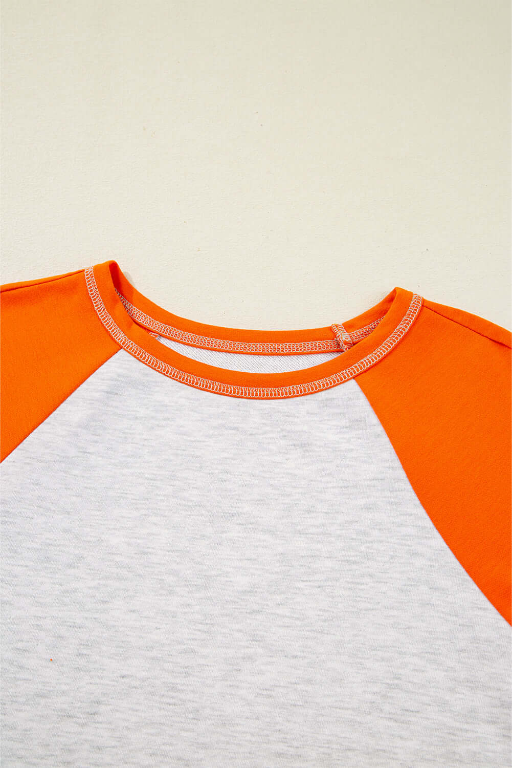 CITRUS CRUSH TOP featuring vibrant orange sleeves and a light grey body for a stylish look.