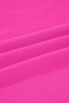 Close-up of vibrant crinkled fabric texture in bright pink for GRACEFUL GLOW TOP (bright pink).