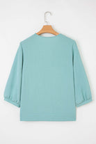 Back view of the GRACEFUL GLOW TOP (jade sea) featuring a chic design and elegant bracelet sleeves.