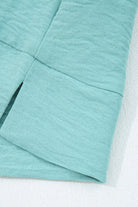 Close-up of the crinkled fabric of the GRACEFUL GLOW TOP (jade sea) showcasing its elegant texture and color.