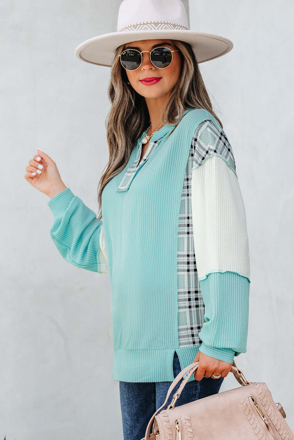 Model wearing AQUA AVENUE TOP featuring plaid patchwork and ribbed texture, styled with sunglasses and a hat.