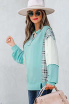 Model wearing AQUA AVENUE TOP featuring plaid patchwork and ribbed texture, styled with sunglasses and a hat.