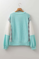 Aqua Avenue Top ribbed pullover showcasing playful patchwork design and relaxed fit in aqua and plaid.