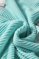 Close-up of textured aqua fabric showcasing the corded ribbed design of AQUA AVENUE TOP.