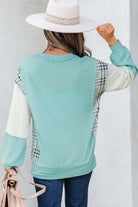 Aqua Avenue Top - Back view of a woman wearing a ribbed pullover with plaid and colorblock patchwork design.