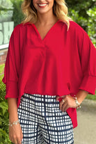 Model wearing TRUE PASSION TOP in fiery red, paired with checkered pants, showcasing effortless style and comfort.