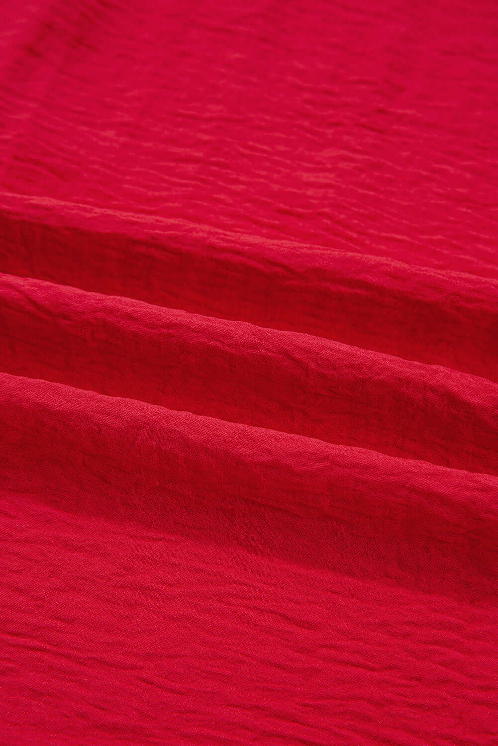 Texture of the fabric in the TRUE PASSION TOP showcasing a vibrant fiery red color.