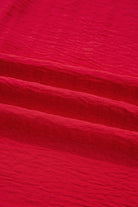Texture of the fabric in the TRUE PASSION TOP showcasing a vibrant fiery red color.