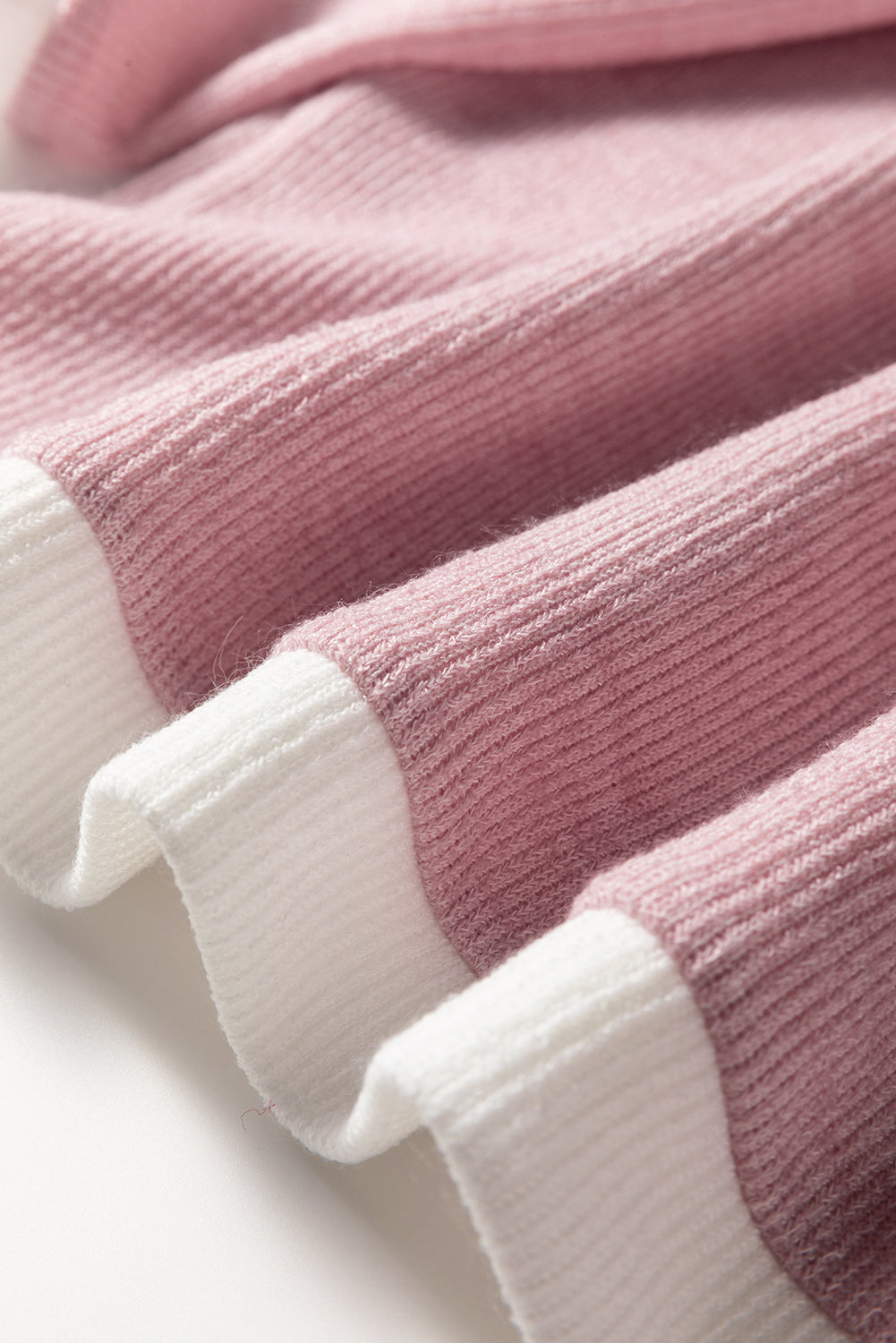Close-up of the soft knit texture and contrast trim of the BLUSHLINE BEAUTY TOP in blush pink and white.