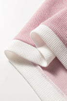 Close-up of the soft knit fabric and contrast trim of the BLUSHLINE BEAUTY TOP in blush and white.