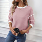 Woman wearing a stylish BLUSHLINE BEAUTY TOP in soft blush with contrast trim, holding a coffee cup.