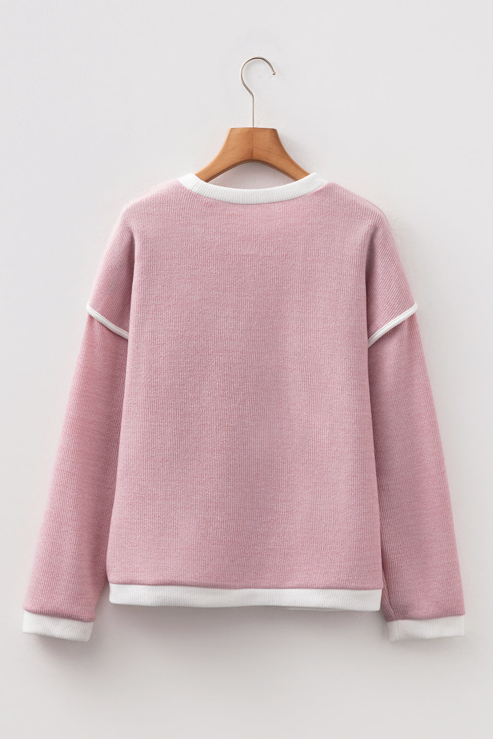 Back view of BLUSHLINE BEAUTY TOP in soft blush hue with contrast trim detailing on sleeves and neckline.