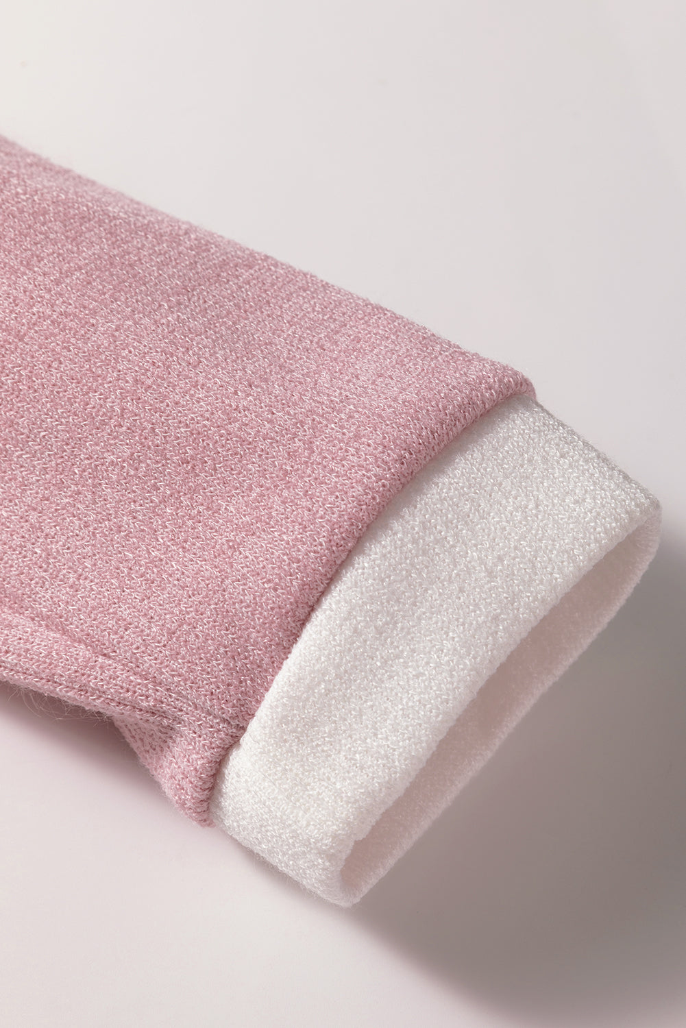 Close-up of the soft knit texture and contrast trim of the BLUSHLINE BEAUTY TOP in blush pink and white.