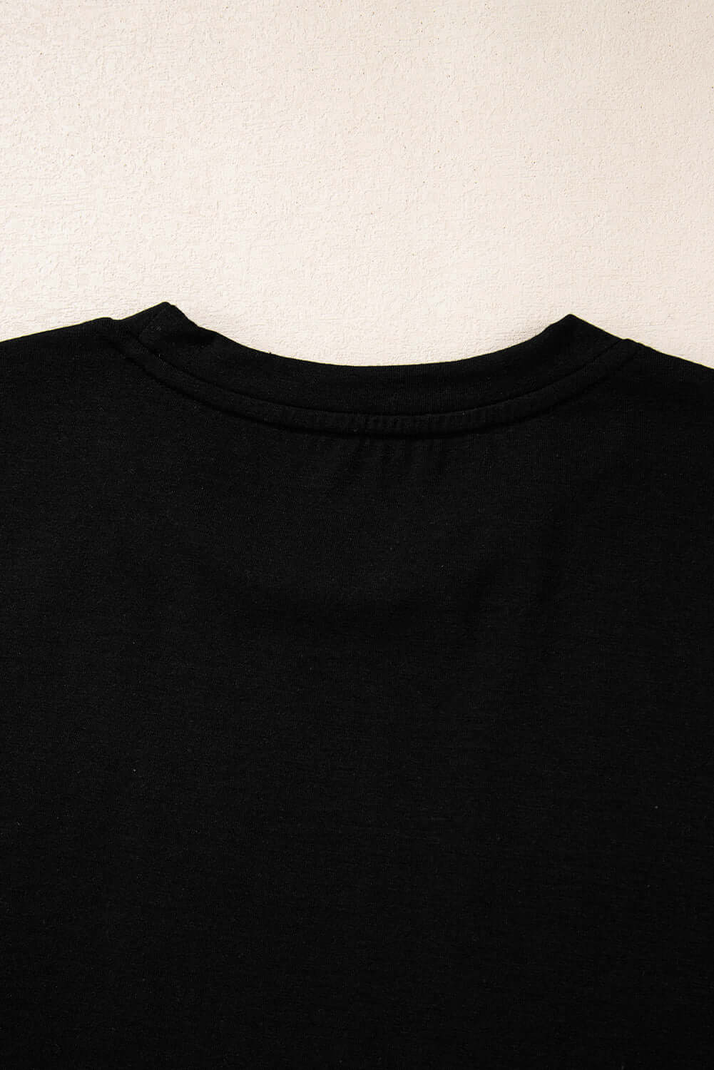 Close-up of the black T-shirt's crew neck design, showcasing soft fabric and comfortable fit.