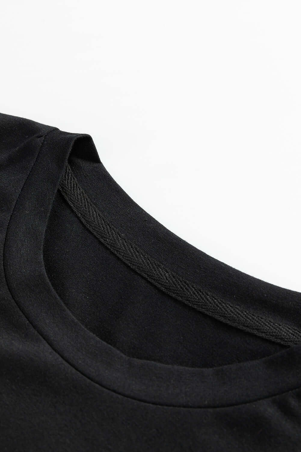 Close-up of the black neckline of the festive Dance of the Nutcracker T-shirt, showcasing its comfortable fabric.