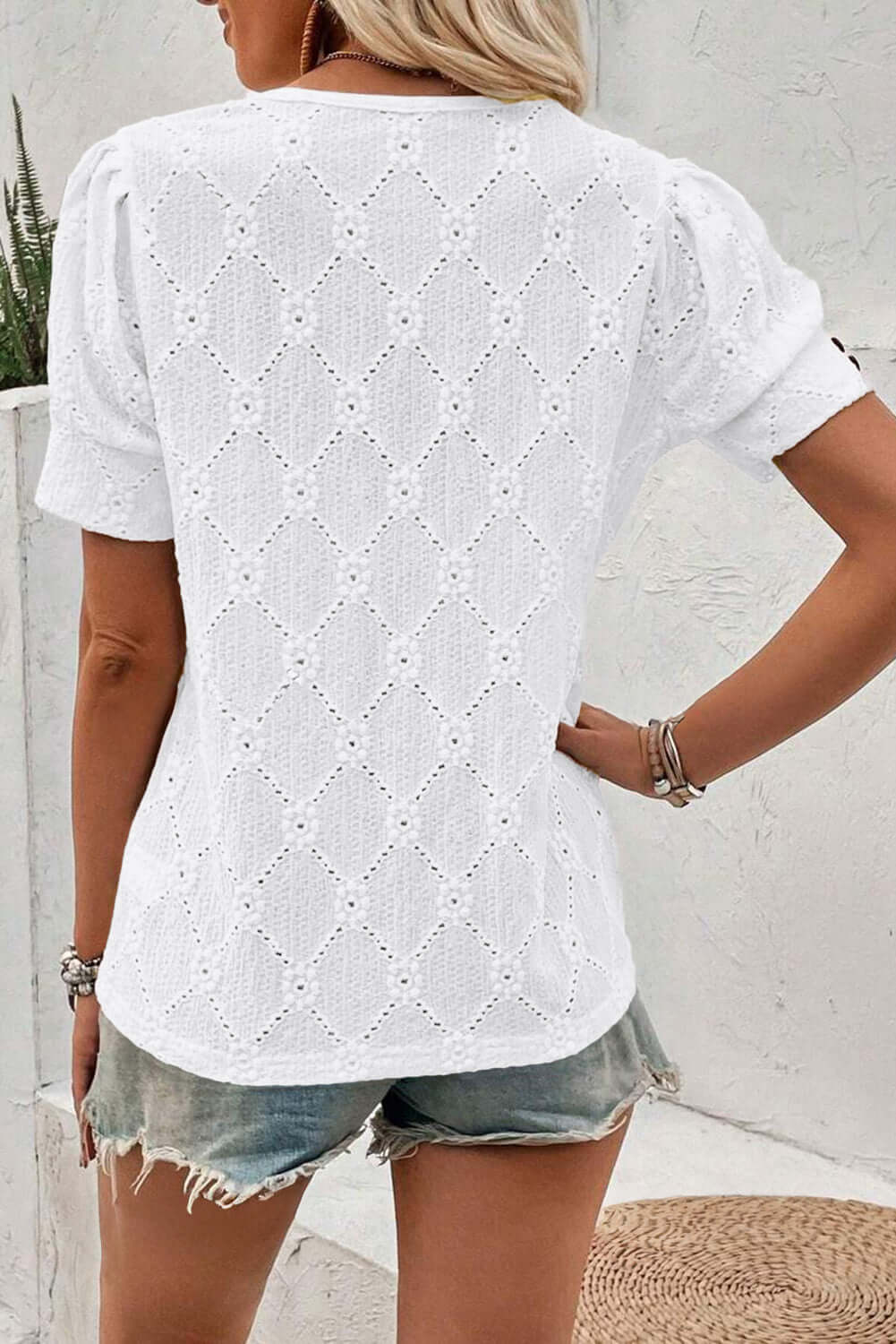 White Lattice & Lace top featuring a textured diamond pattern and short sleeves, styled with denim shorts.