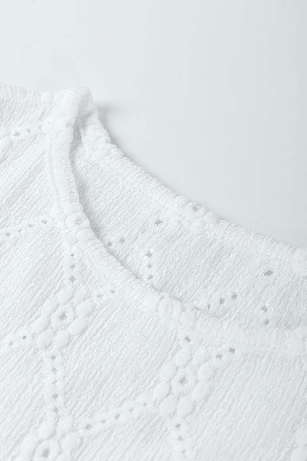 Close-up of Lattice & Lace top showcasing delicate floral and diamond textured fabric in white.