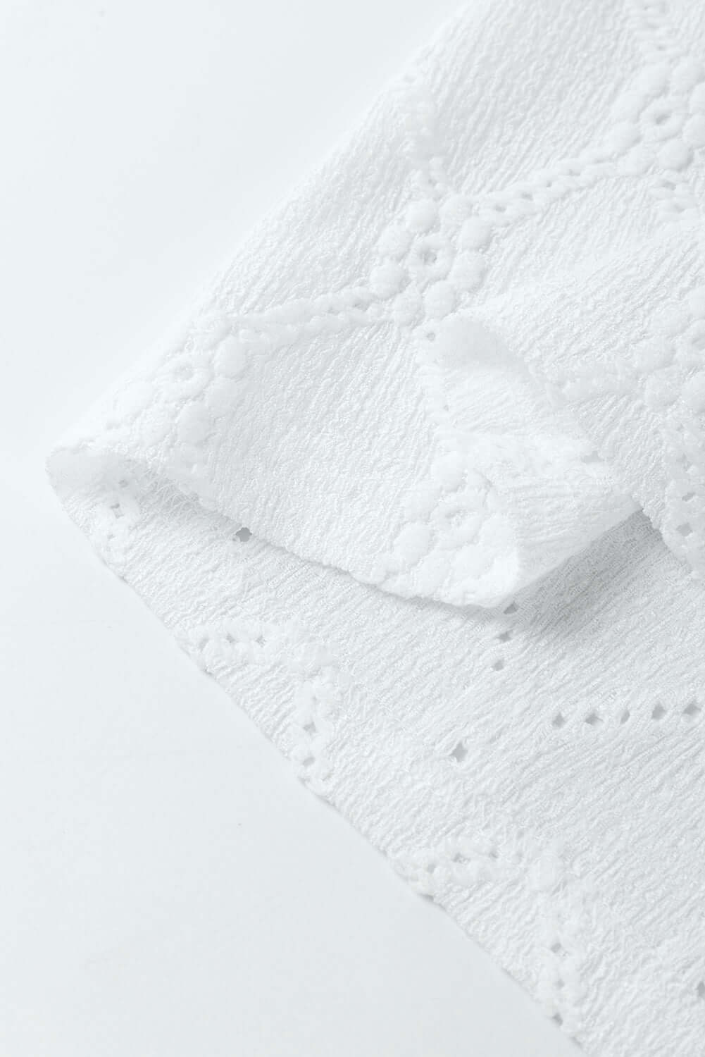 Close-up of the textured white fabric showcasing floral and geometric details for the Lattice & Lace top.