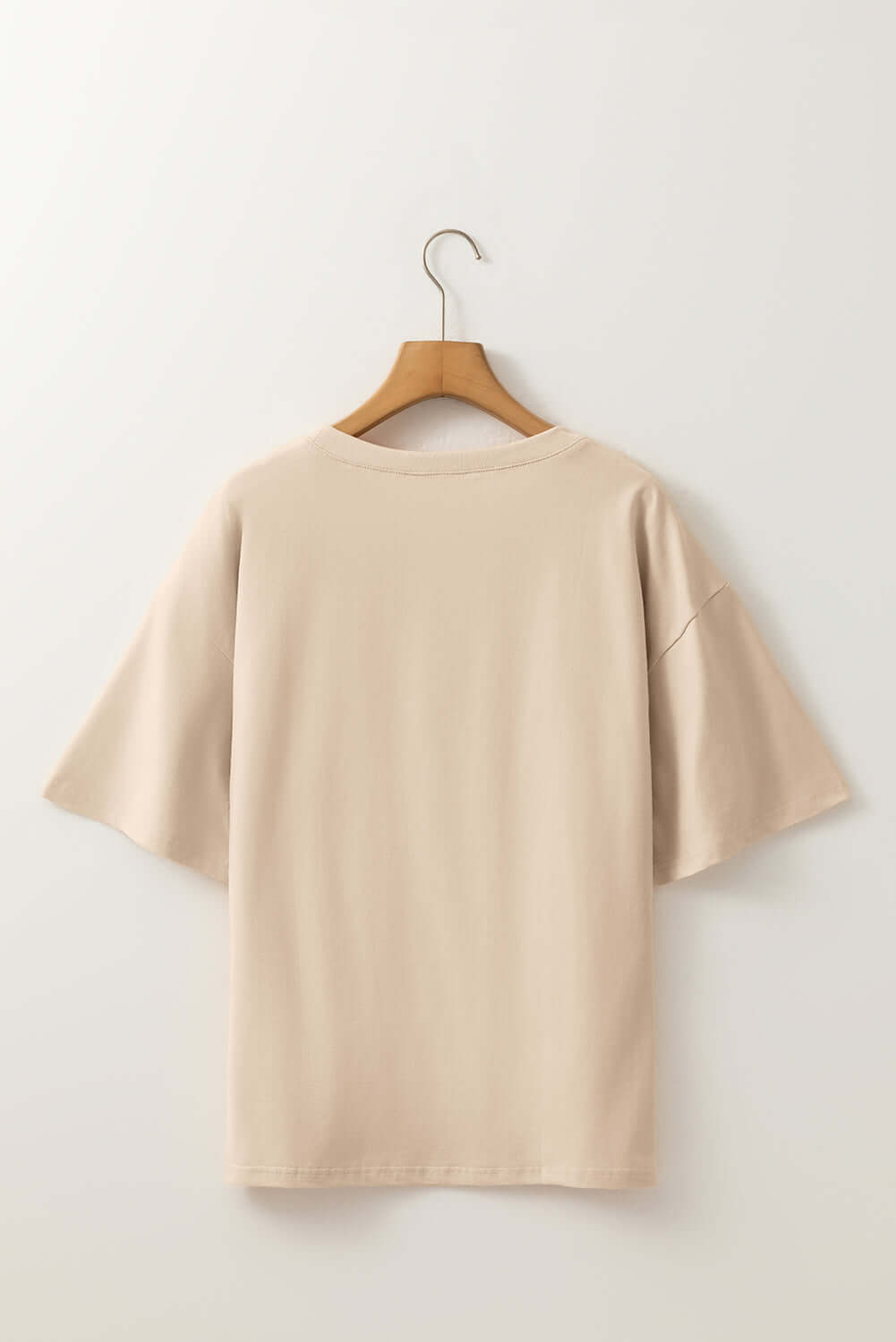 Back view of the Morning Daisy crochet floral graphic drop shoulder loose tee on hanger.