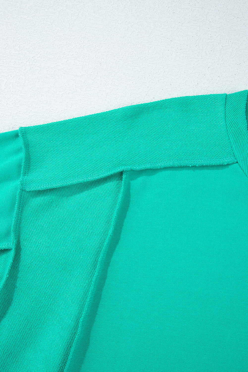 Close-up of the Teal We Meet Again Crewneck sweatshirt showcasing its structured design and splicing details.