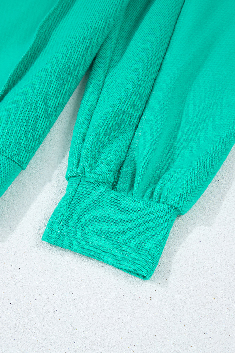 Close-up of teal fabric and cuff details of the Teal We Meet Again Crewneck sweatshirt.