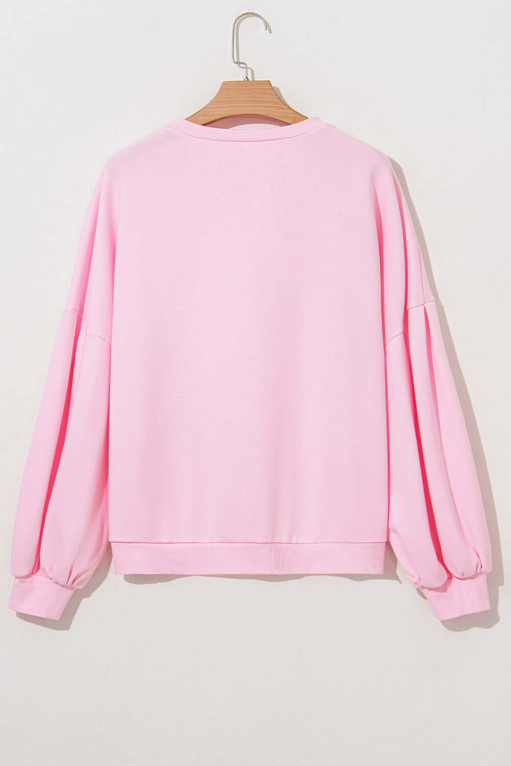 Back view of THE BOWTIQUE Top (pink) showcasing its lantern sleeves and soft pink color.