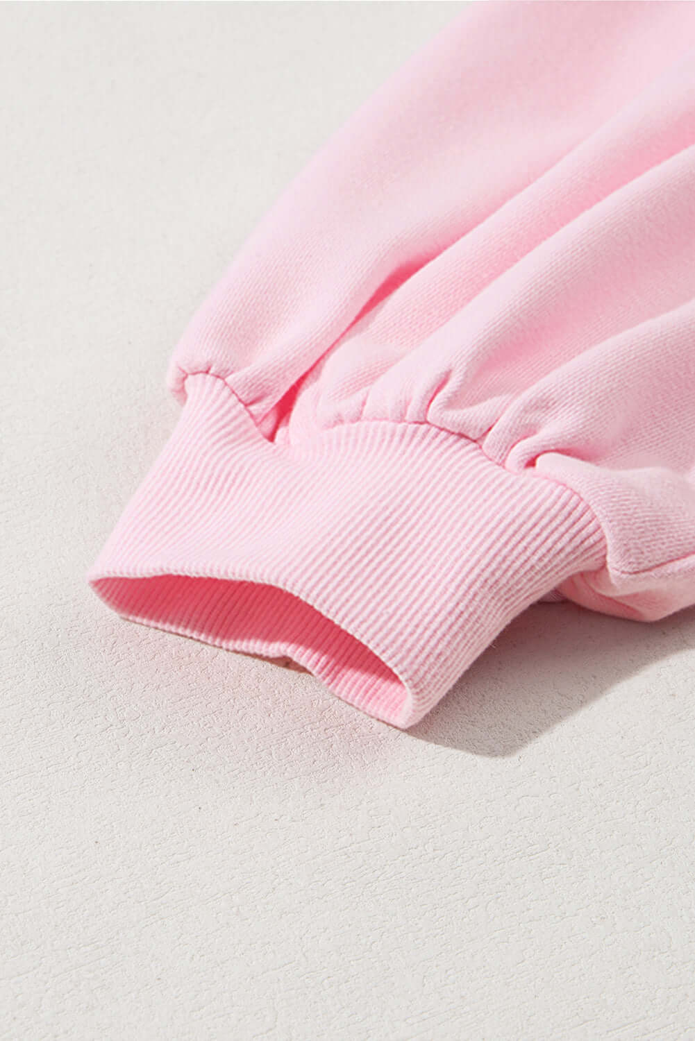 Close-up of the sleeve detail on THE BOWTIQUE Top (pink) with gathered cuffs in soft baby pink fabric.