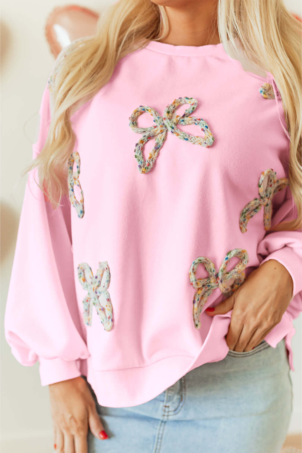 THE BOWTIQUE Top (pink) featuring embroidered bows on a baby pink pullover with lantern sleeves.