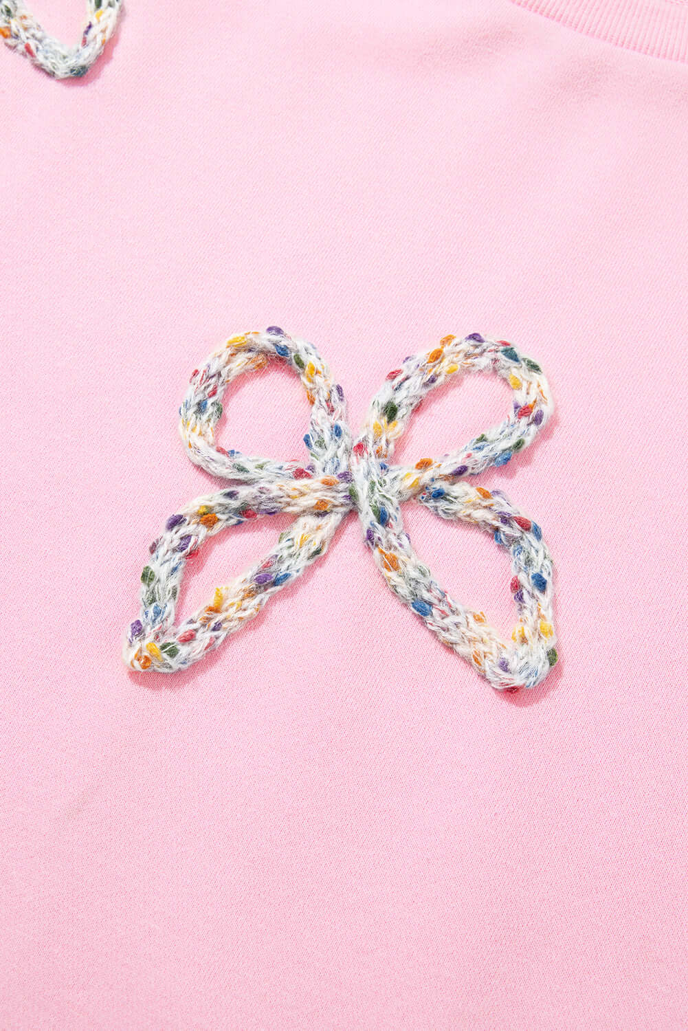 Close-up of embroidered bow detail on THE BOWTIQUE Top (pink) showcasing chic design elements.