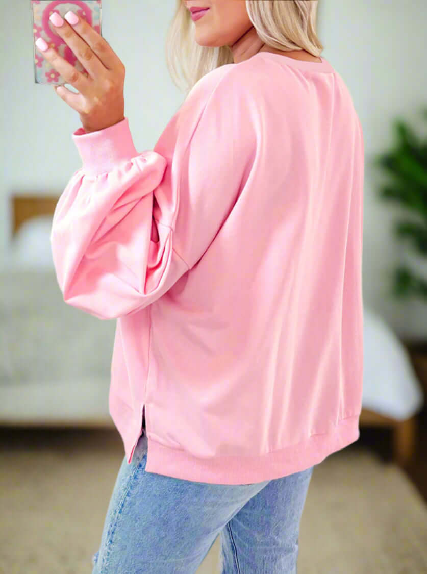 Model wearing THE BOWTIQUE Top (pink), showcasing its chic design and lantern sleeves.