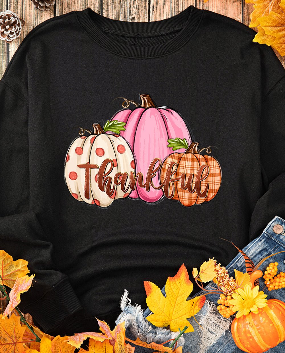 Black crewneck with 'Thankful' text and colorful pumpkin graphic, perfect for cozy Thanksgiving wear.