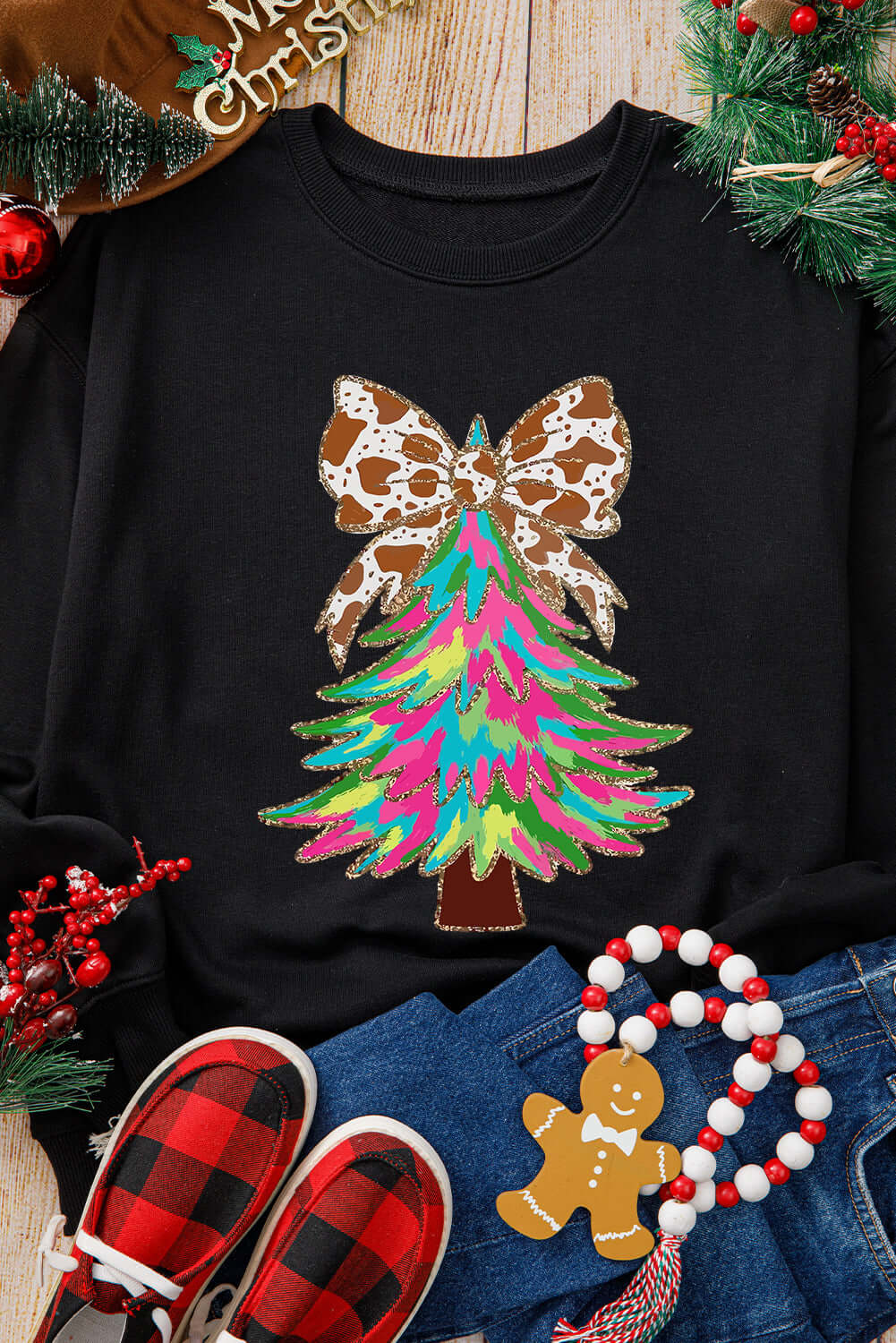 Colorful Christmas tree sweatshirt featuring a unique animal-print bow on a black background.