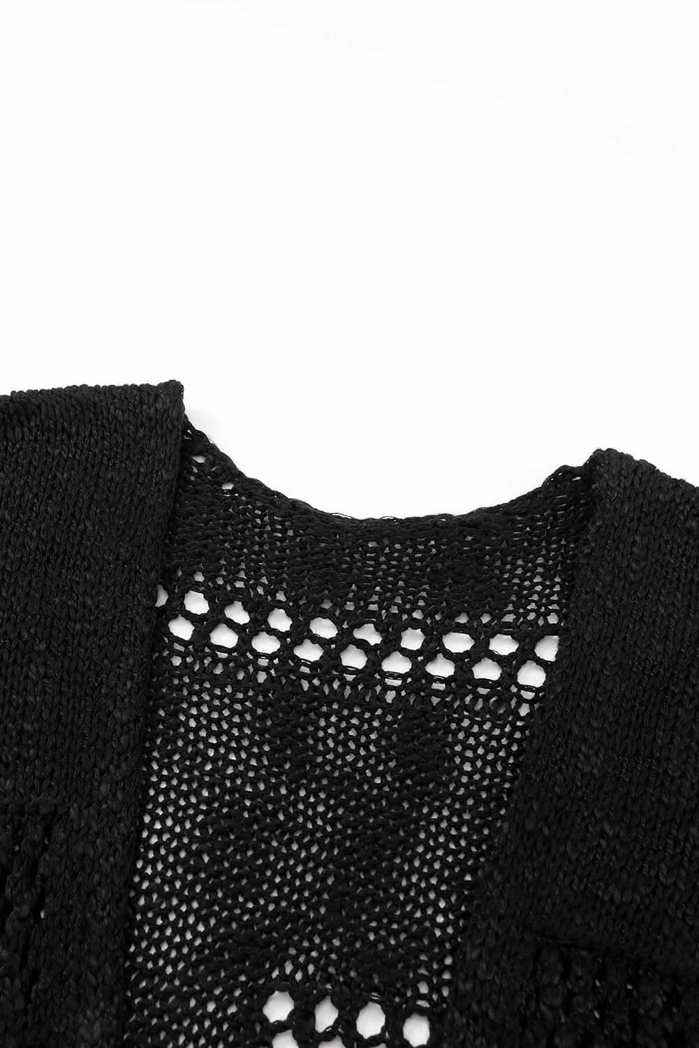 Close-up of the Blackout Bliss Cardigan's open cable-knit design showcasing black yarn and relaxed silhouette.