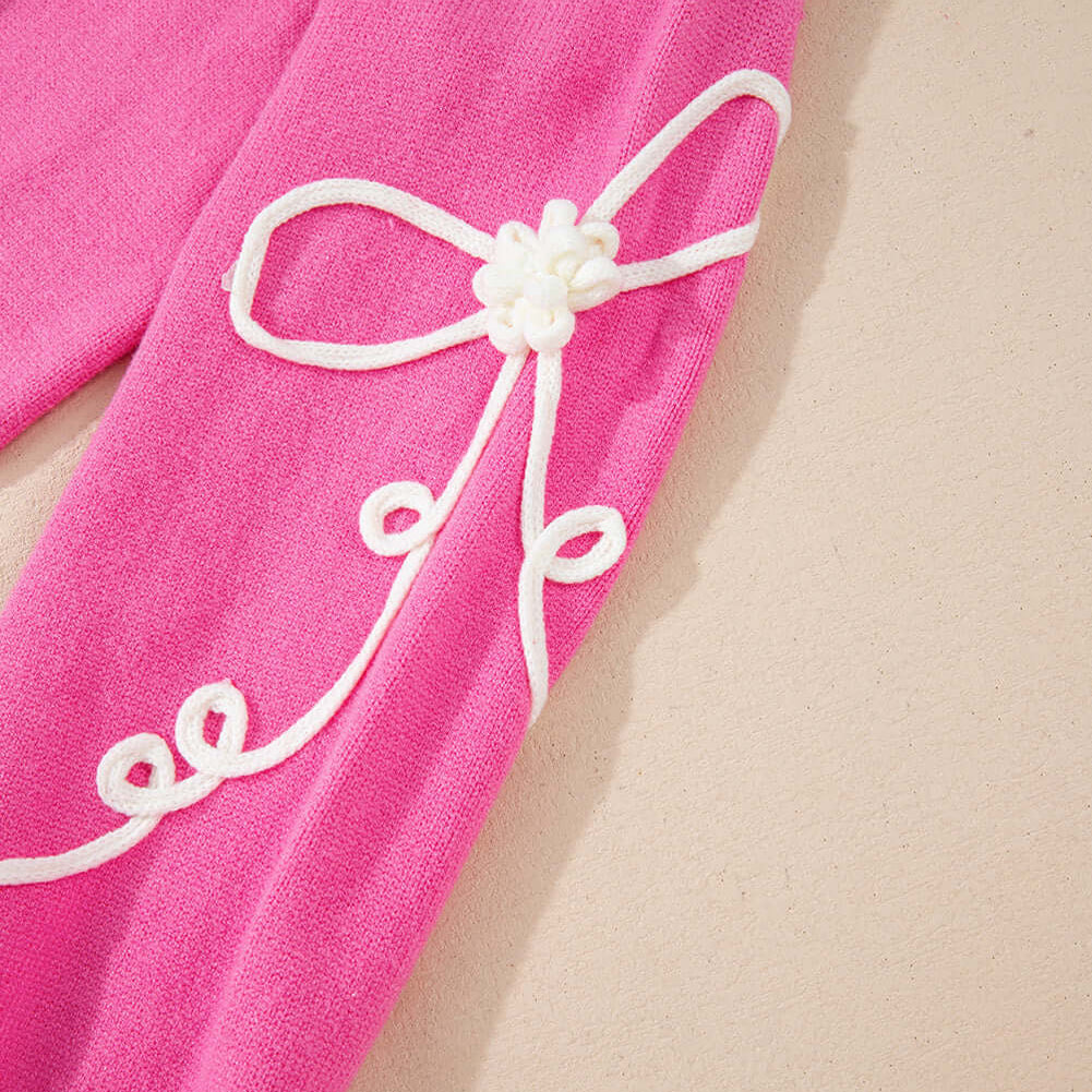 Close-up of the TRIP TO REMEMBER Sweater in pink, showcasing the corded bow accents and playful details.
