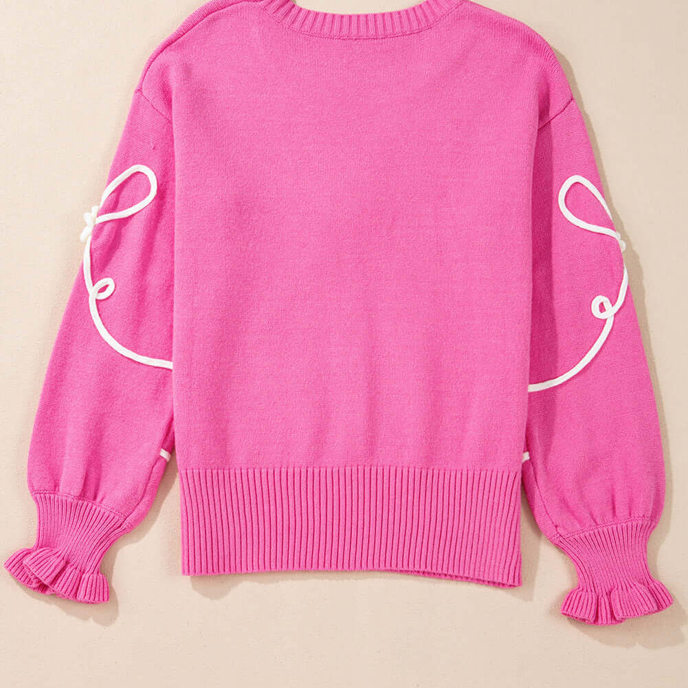 Back view of TRIP TO REMEMBER Sweater showcasing corded bow accents and ruffled cuffs in bright pink.