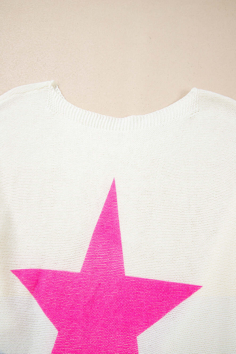 Back view of the STARSTRUCK SWEATER showcasing a bold pink star design against a soft white background.