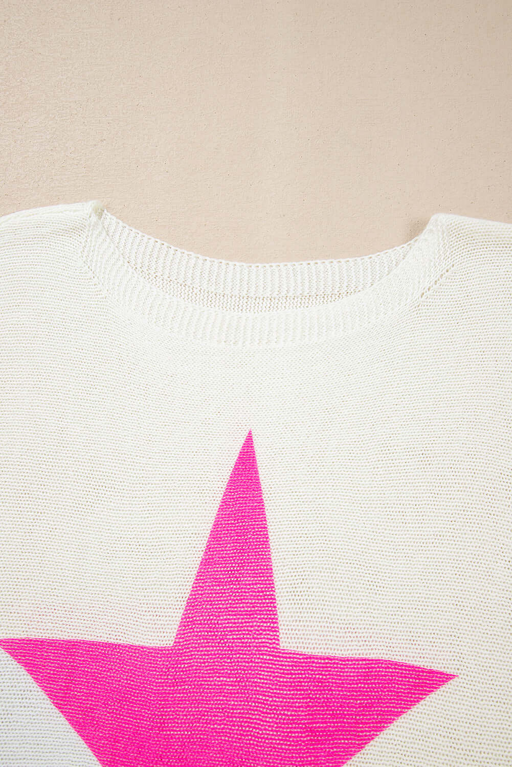 Close-up of the collar and bold pink star design on the STARSTRUCK SWEATER, showcasing its playful charm.