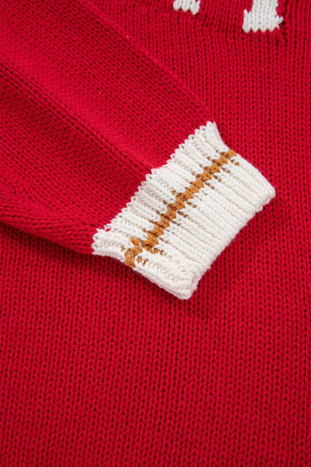 Close-up of the MERRY MOMENTS SWEATER featuring a red knit sleeve with a cream and brown ribbed cuff.
