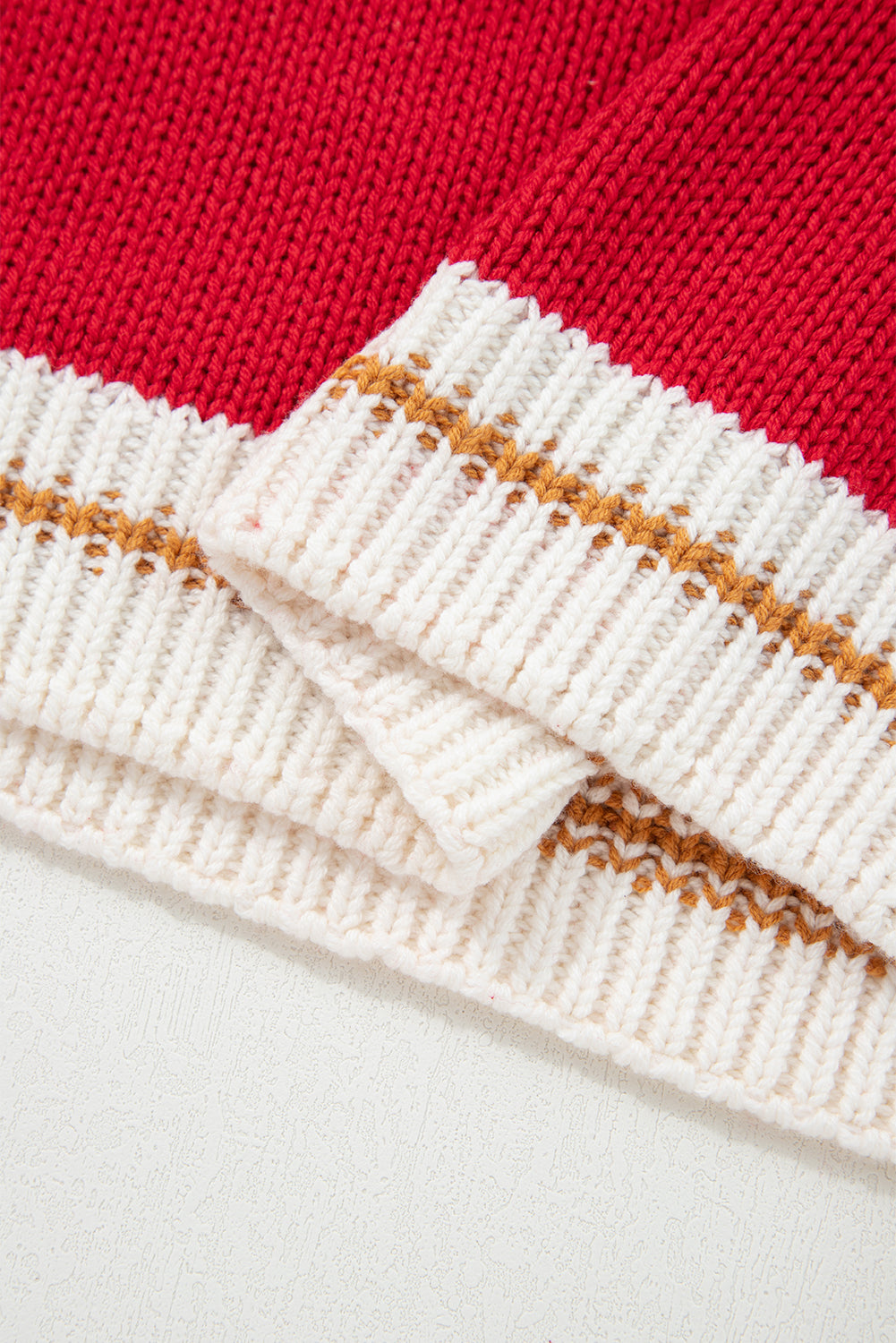 Close-up of the MERRY MOMENTS SWEATER showing the cozy red fabric and color block trim detail.