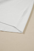 Detail of the MOUNTAIN AIR SWEATER in cream color, showcasing the ribbed knit texture on a beige background.