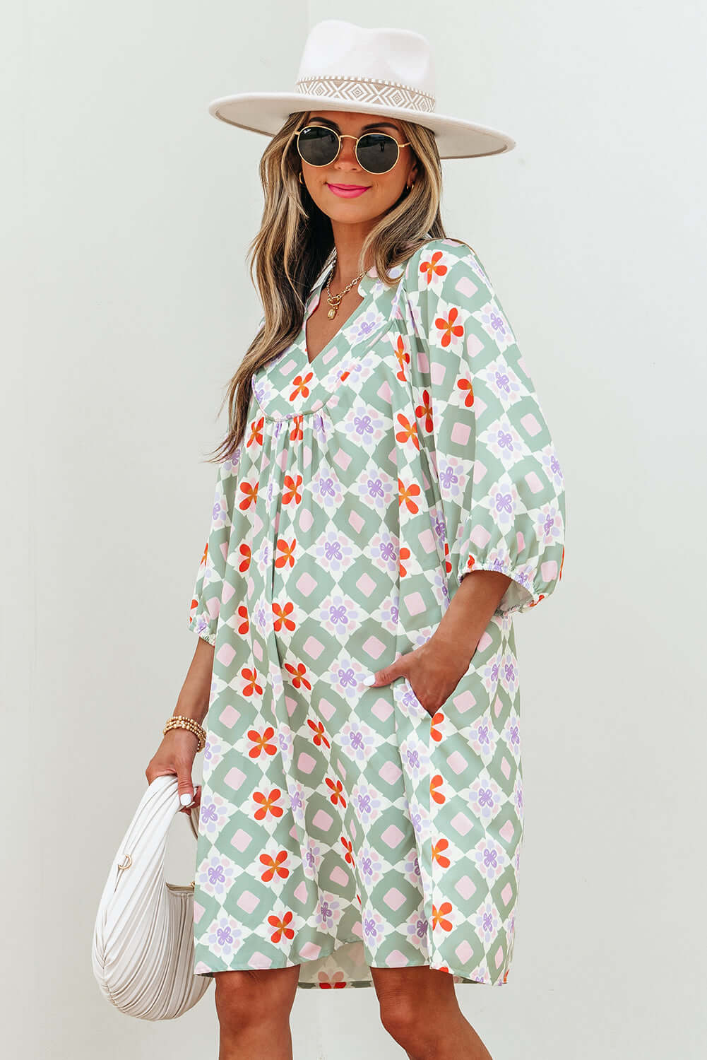 Model wearing a mint mosaic dress with green floral pattern, V-neck, and 3/4 puff sleeves.