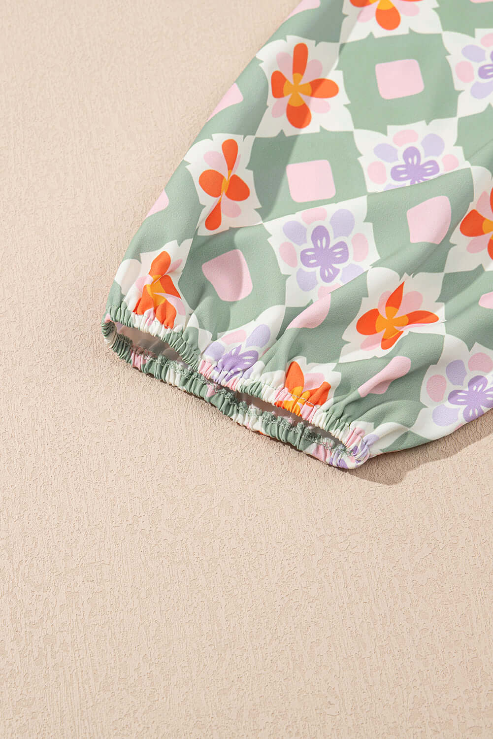Close-up of the Mint Mosaic Dress showcasing colorful geometric floral print and elasticized sleeve detail.