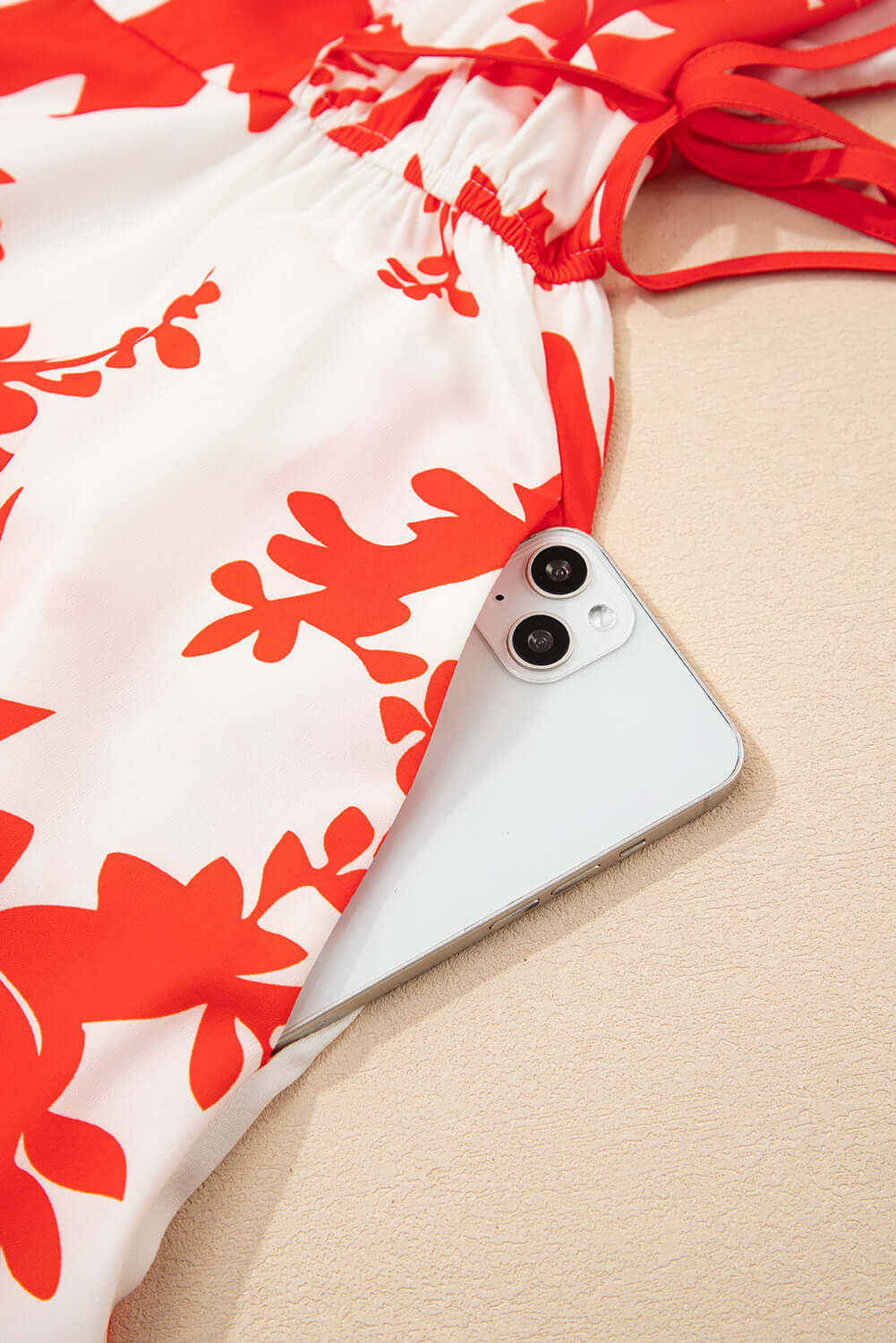 Salsa Garden Dress with red floral print and a smartphone tucked in the skirt, perfect for summer outings.
