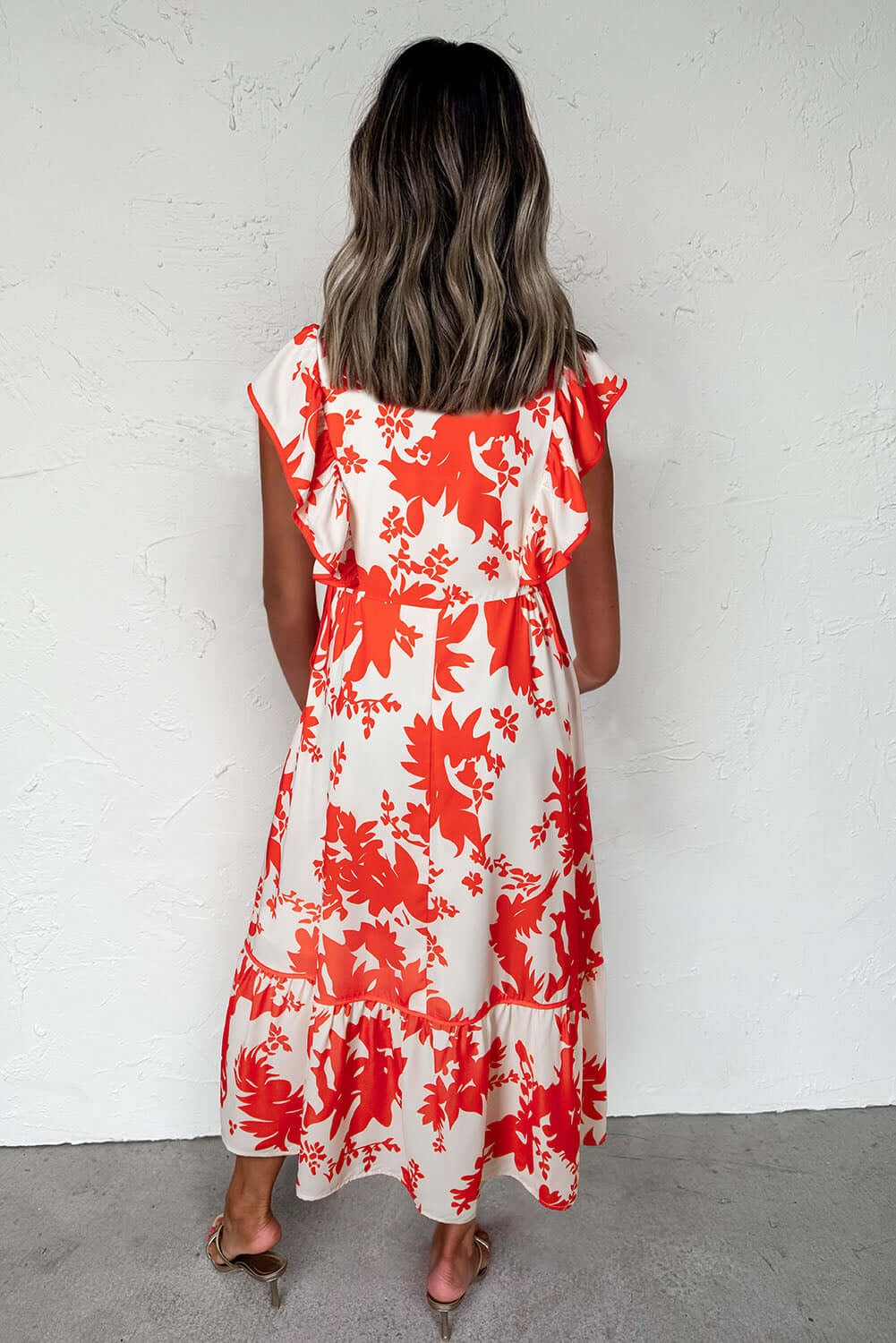 Back view of a woman wearing a Salsa Garden Dress featuring red floral print on ivory, perfect for summer outings.