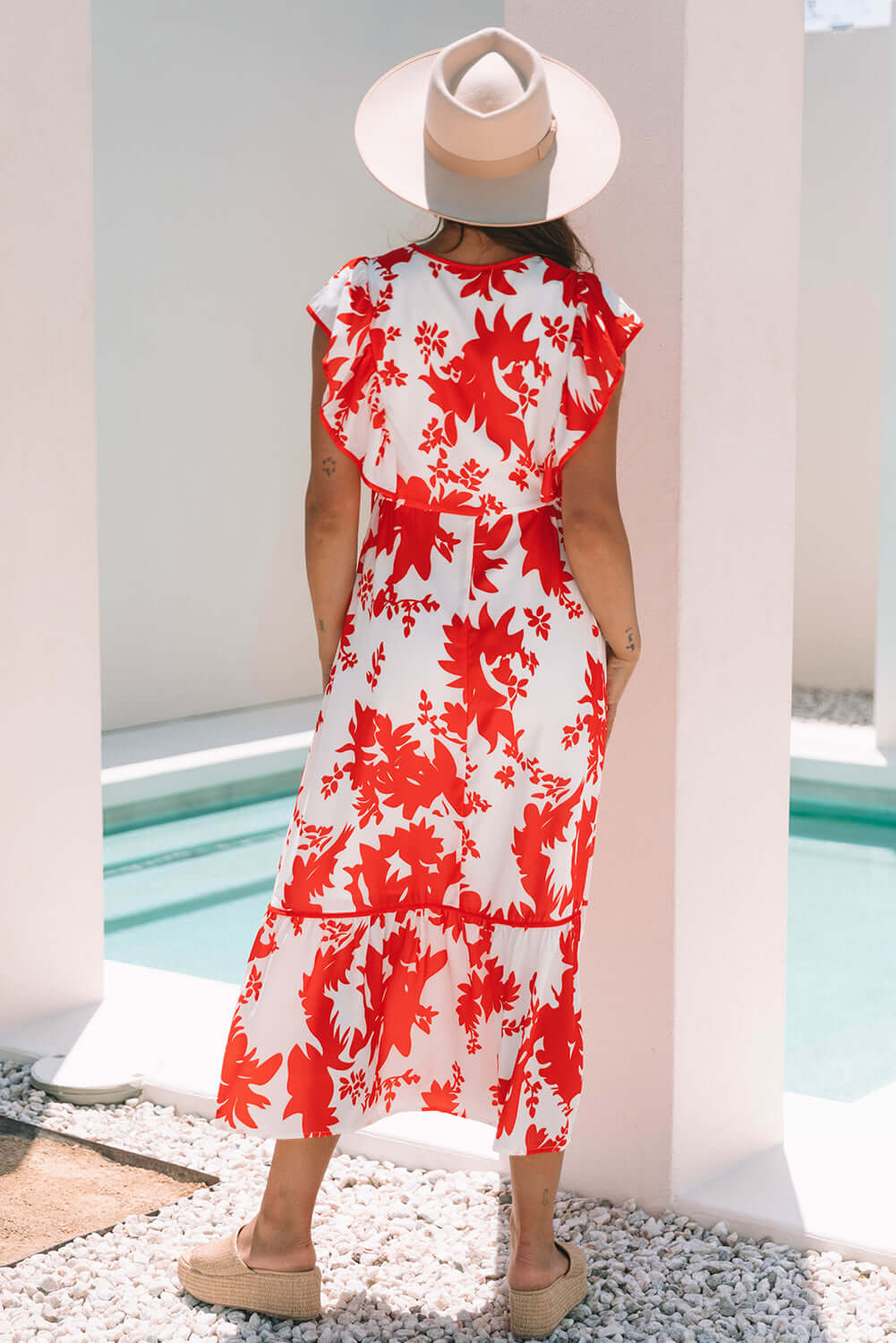 Back view of a woman in a red floral Salsa Garden Dress, perfect for summer outings by the pool.