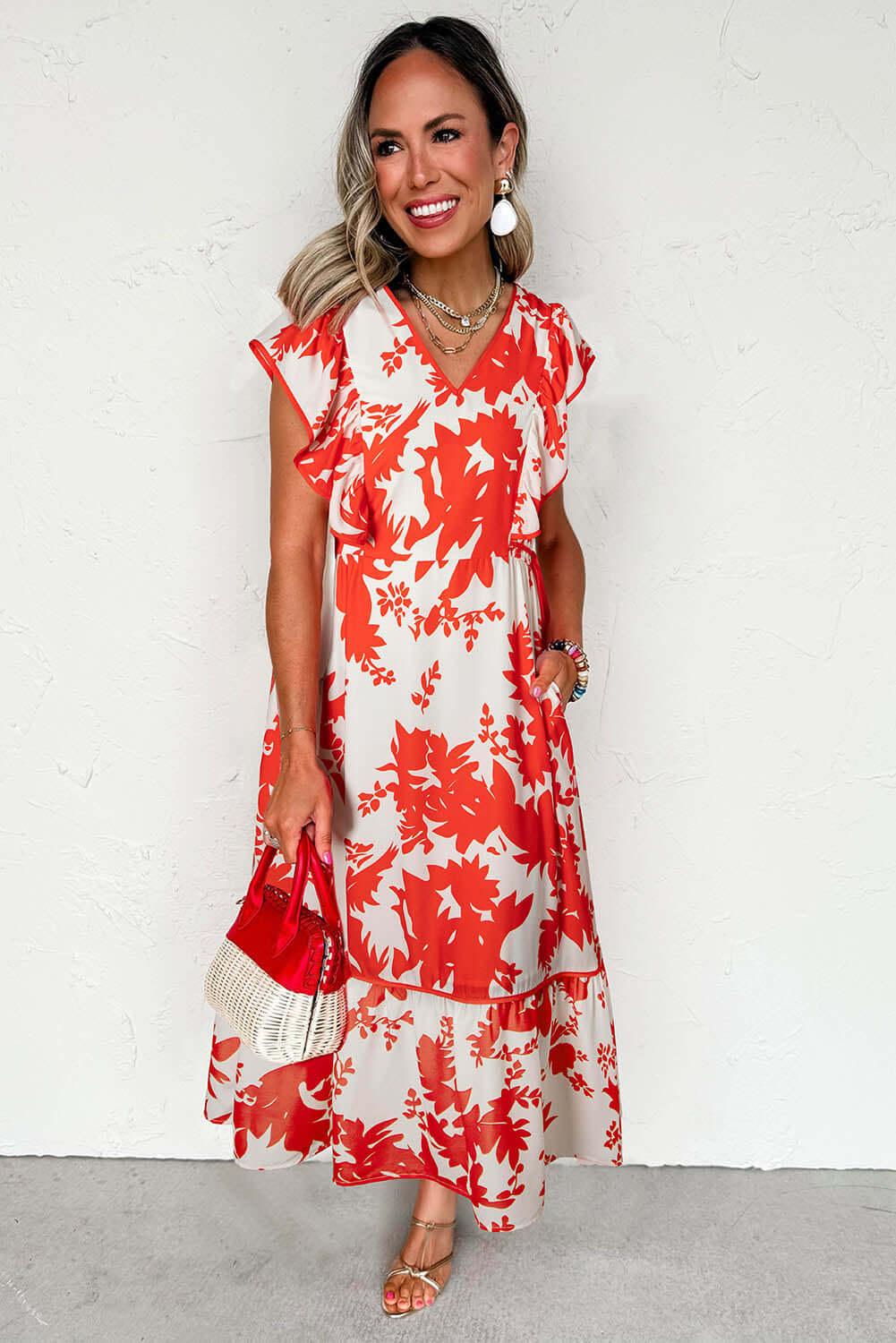 Woman wearing a red floral print Salsa Garden Dress with flutter sleeves, perfect for summer outings and brunch.